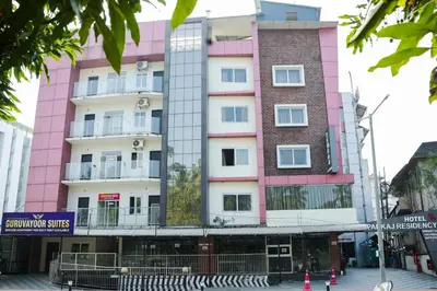 a pink building in the middle of a street at Gokulam suits guruvayur in Guruvāyūr