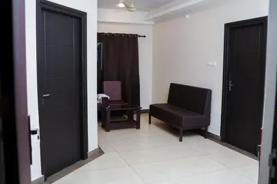 a living room with a black chair and a chair at Gokulam suits guruvayur in Guruvāyūr