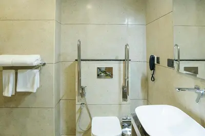 a bathroom with a toilet and a sink and a phone at Chaliyar Resorts