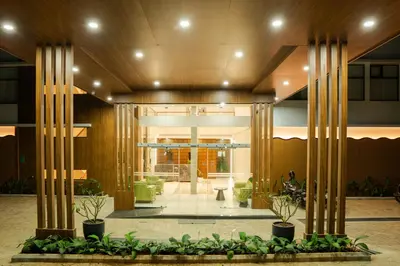 a lobby of a building with columns and plants at Chaliyar Resorts