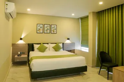 a bedroom with a bed and a green curtain at Chaliyar Resorts