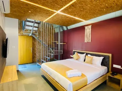 a bedroom with a large bed with a red wall at ivaana resorts mysore in Mysore