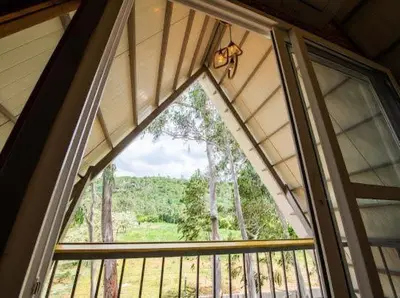 a window in a room with a view of a forest at ivaana resorts mysore in Mysore