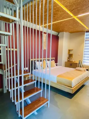 a bedroom with a bed and a loft bed with wooden ceilings at ivaana resorts mysore in Mysore