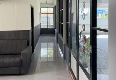 a hallway with a couch and a glass door at Hotel Alka Inn Residency Wayanad in Sultan Bathery