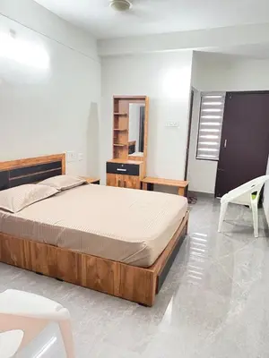 a bedroom with a bed and a desk and a chair at Hotel Alka Inn Residency Wayanad in Sultan Bathery