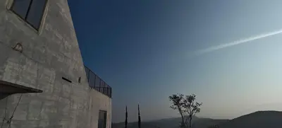 a large stone building with a tree in the foreground at Spirit of the Wild Mountain Retreat in Attappādi