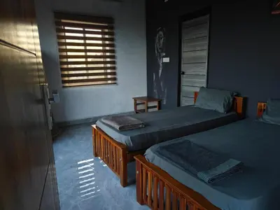 a bedroom with two beds and a window at Spirit of the Wild Mountain Retreat in Attappādi