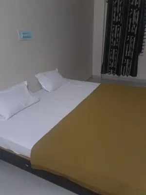 a large bed in a room with a window at Shreyas Residency in Mysore