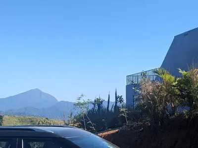 a car parked on a road with mountains in the background at Spirit of the Wild Mountain Retreat in Palakkad