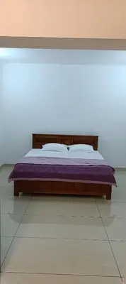 a bedroom with a bed with a purple blanket at Metta Heaven Farm Resort in Kodenchery