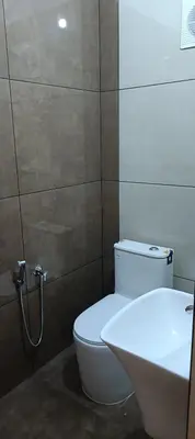 a bathroom with a white toilet and a sink at Metta Heaven Farm Resort in Kodenchery