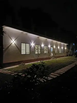 a building with lights on the side of it at night at Metta Heaven Farm Resort in Kodenchery