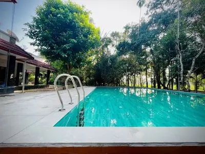 a swimming pool with aicrobialicrobialicrobialicrobialicrobialicrobial at Lush Orchard in Kizhake Chālakudi