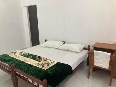 a bedroom with a bed and a nightstand and a bed sidx sidx at Valiyaveettile in Alwaye