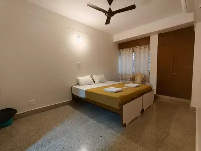 a bedroom with a bed with a ceiling fan at Raviudaya-2bhk in Mysore