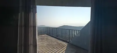 a room with a balcony with a view of the mountains at Spirit of the Wild Mountain Retreat Attapadi in Attappādi