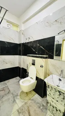 a bathroom with a toilet and a sink at SKB Suites in Mysore