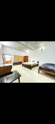 a living room with two beds and a couch at The 77 estate stay coorg in Suntikoppa
