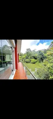 a building with a view of a river from a balcony at The 77 estate stay coorg in Suntikoppa