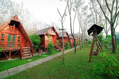 a group of small houses in a field of grass at Bali bamboo in Padinjarathara
