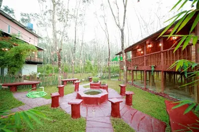 a patio with benches and a fountain next to a building at Bali bamboo in Padinjarathara