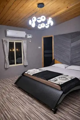 a bedroom with a large bed and a chandelier at The Farmville kodaikanal in Kodaikānāl