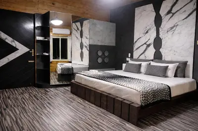 a bedroom with a large bed with a marble wall at The Farmville kodaikanal in Kodaikānāl