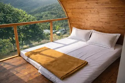 a bed in a room with a large window at The Farmville kodaikanal in Kodaikānāl