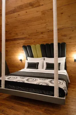 a bed in a room with wooden walls at The Farmville kodaikanal in Kodaikānāl