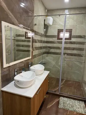 a bathroom with two sinks and a shower at Premium house near Cochin Airport for NRI families in Nedumbassery