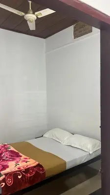 a bed in a room with a ceiling fan at Pookode Service Villa in Vythiri