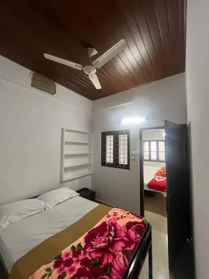 a bedroom with a bed and a ceiling fan at Pookode Service Villa in Vythiri