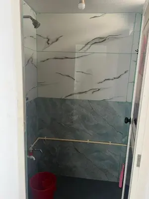 a shower with a glass door in a bathroom at Pookode Service Villa in Vythiri