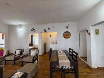 a living room with a dining table and chairs at Sunflower Villa Cottage Coonoor in Coonoor