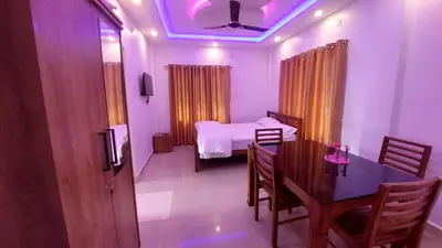 a room with a table and a bed and a dining room at Caramel stay in Marayoor