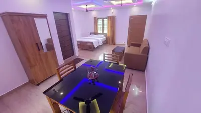 a room with a dining table and a living room at Caramel stay in Marayoor