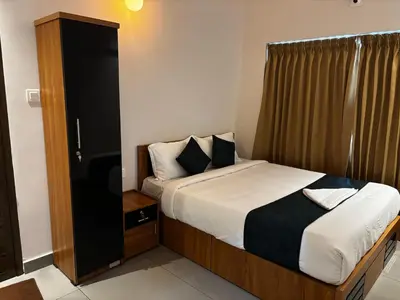 a bedroom with a bed and a small cabinet at Nellarachal Homestay in Ambalavayal