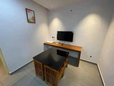 a room with a desk with a television on a wall at Nellarachal Homestay in Ambalavayal