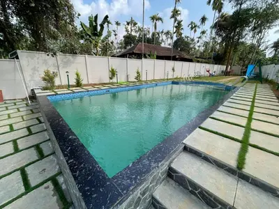 a swimming pool with green water in a yard at Nellarachal Homestay in Ambalavayal