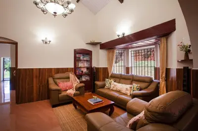 a living room with two couches and a coffee table at Wyncroft Bed and Breakfast, Heritage Bungalow at Kotagiri in Kotagiri