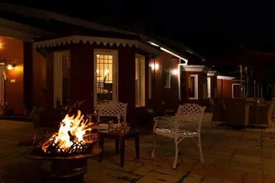 a fire pit in front of a house at night at Wyncroft Bed and Breakfast, Heritage Bungalow at Kotagiri in Kotagiri