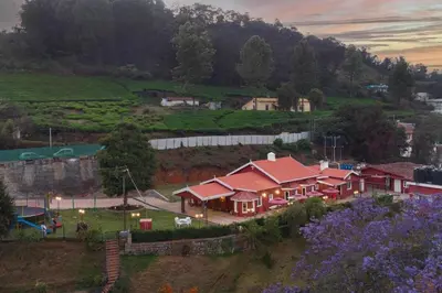 a large house with red roofs on a hill at Wyncroft Bed and Breakfast, Heritage Bungalow at Kotagiri in Kotagiri