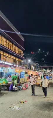 a group of people walking through a market at night at Shri Bhagawathi Residency in Palani
