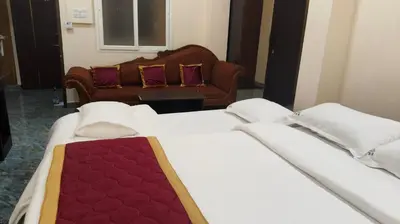 a hotel room with two beds and a couch at Shri Bhagawathi Residency in Palani
