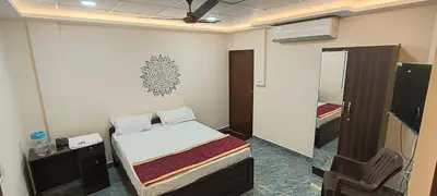 a small room with a bed and a mirror at Shri Bhagawathi Residency in Palani