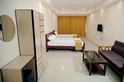 a hotel room with a bed and a couch at Amritha Lodge in Kollengode