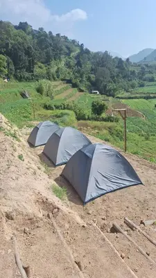 a group of three tents in a dirt field at Secret valley vattavada in Vattavada