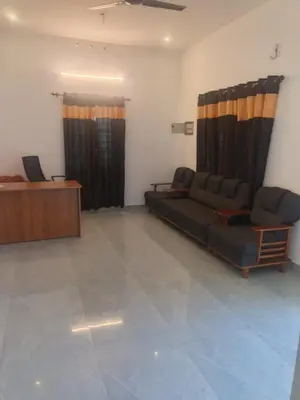 a living room with a couch and a desk at Sandal Homestay in Marayoor