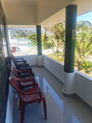 a row of chairs on a balcony with a view of the beach at Sandal Homestay in Marayoor